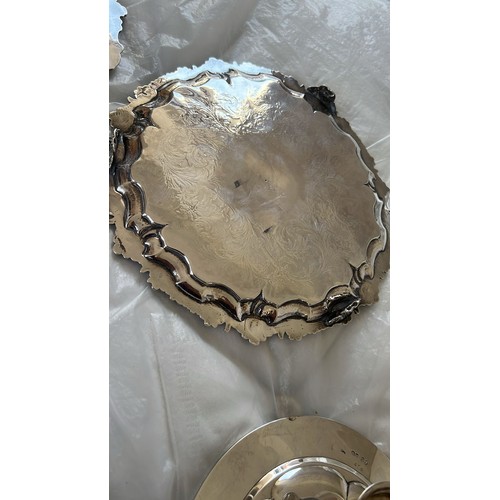 203 - A Victorian round scallop shaped salver with raised and engraved floral and leaf decoration, on 3 sp... 