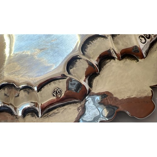 203 - A Victorian round scallop shaped salver with raised and engraved floral and leaf decoration, on 3 sp... 