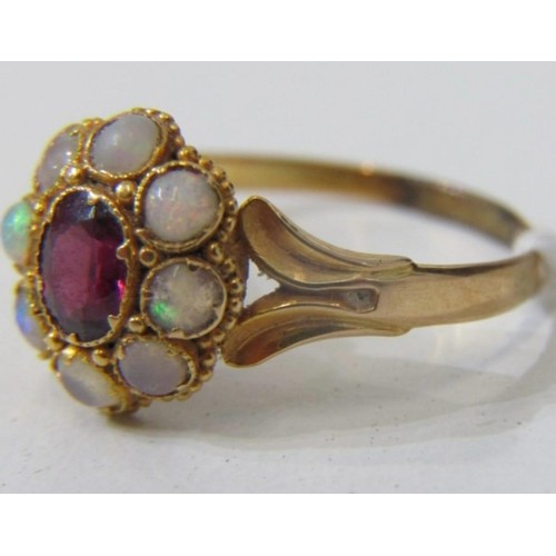 63 - OPAL AND ruby like RING, a yellow gold ring high karat gold set with a central oval garnet surrounde... 