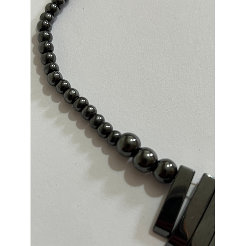 1619 - hematite bib or collar necklace featuring a graduated fringe design. The necklace is made from dark ... 