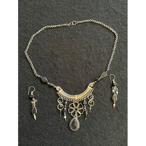 1857 - An Indian white metal necklace and earring set with black agate type stones.