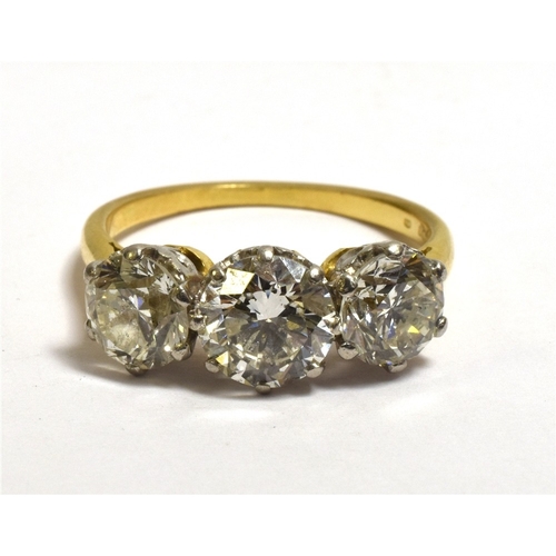 26 - A THREE STONE BRILLIANT CUT DIAMOND RING Estimated in the setting to total 3.1 carats, with diamond ... 