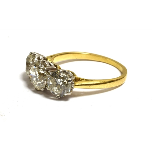 26 - A THREE STONE BRILLIANT CUT DIAMOND RING Estimated in the setting to total 3.1 carats, with diamond ... 