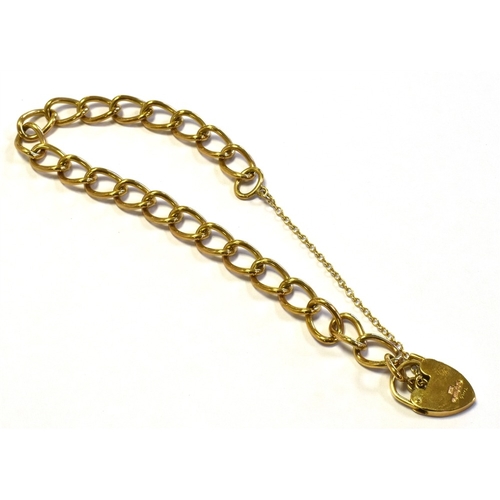 10 - 9CT GOLD CURB LINK BRACELET 18cm long x 7.5mm wide, with heart shaped padlock clasp and safety chain... 