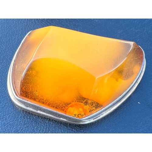 115 - AMBER TOPPED SILVER TRINKET BOX standing 4.5cm tall x 5.3cm long, with a band of embossed floral and... 