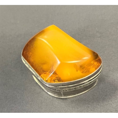 115 - AMBER TOPPED SILVER TRINKET BOX standing 4.5cm tall x 5.3cm long, with a band of embossed floral and... 