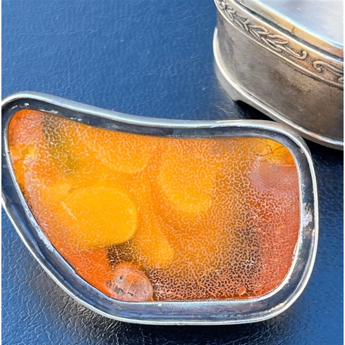 115 - AMBER TOPPED SILVER TRINKET BOX standing 4.5cm tall x 5.3cm long, with a band of embossed floral and... 