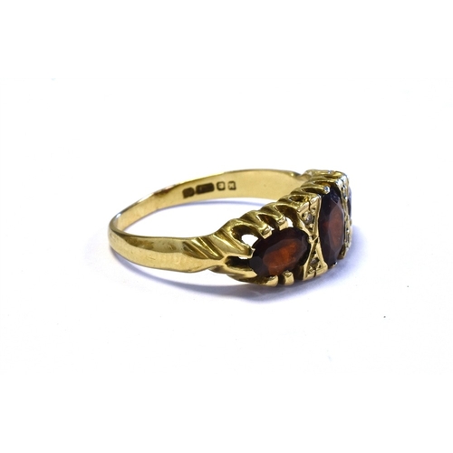 74 - GARNET & DIAMOND TRILOGY RING mounted in 9ct gold and set with three oval cut pyrope garnets and sin... 