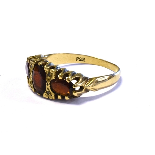 74 - GARNET & DIAMOND TRILOGY RING mounted in 9ct gold and set with three oval cut pyrope garnets and sin... 