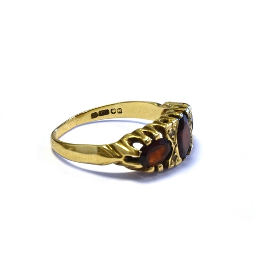 74 - GARNET & DIAMOND TRILOGY RING mounted in 9ct gold and set with three oval cut pyrope garnets and sin... 