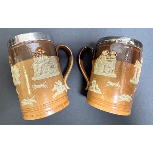 113 - ROYAL DOULTON SILVER MOUNTED TANKARDS a pair, standing 12.8cm tall, with applied Hunt and Tavern sce... 