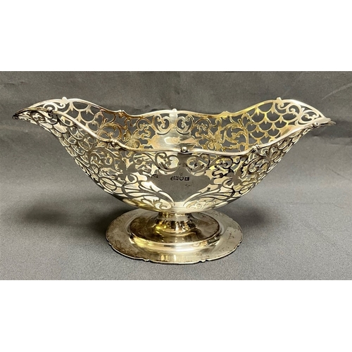 119 - EDWARDIAN STERLING SILVER FRUIT BOWL of oval form, standing 13cm tall x 26cm long x 12cm wide, on lo... 