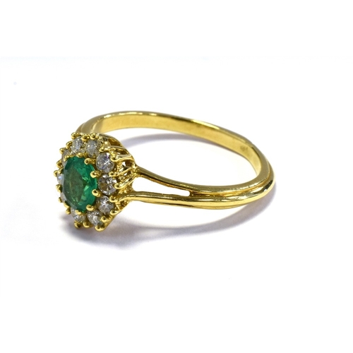 2 - 18CT EMERALD & DIAMOND RING 10.6 x 9.5mm oval cluster, set with an oval emerald, reported as 0.45 ca... 