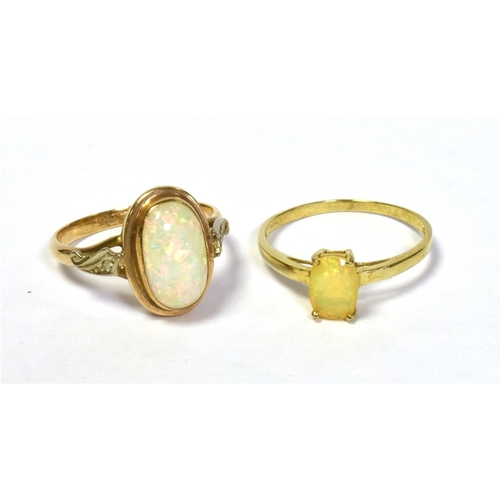 44 - TWO 9CT GOLD & OPAL RINGS one set with an oval fire opal and one set with a solid white opal cabocho... 