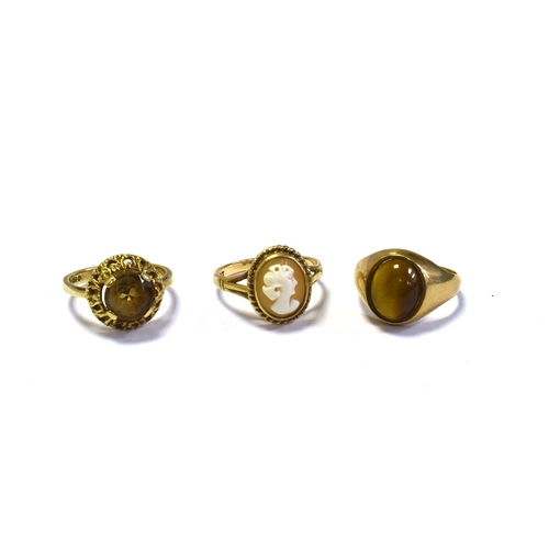 98 - 9CT GOLD SHELL CAMEO & GEM SET RINGS to include; one bezel set tigers eye cabochon, one claw set smo... 