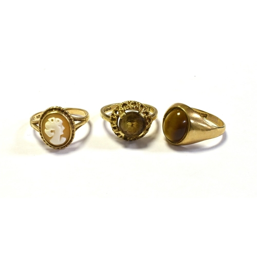 98 - 9CT GOLD SHELL CAMEO & GEM SET RINGS to include; one bezel set tigers eye cabochon, one claw set smo... 