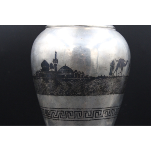 86 - This is an exceptionally large Iraqi silver niello vase adorned with intricate decorations depicting... 