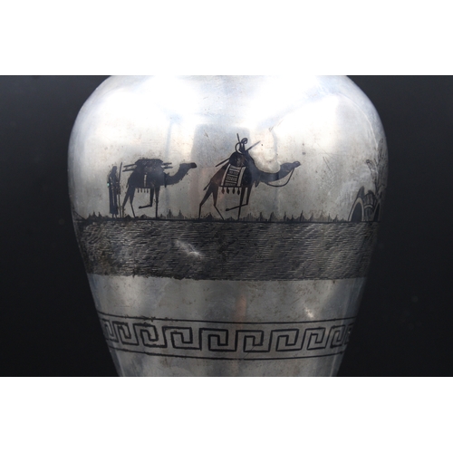 86 - This is an exceptionally large Iraqi silver niello vase adorned with intricate decorations depicting... 