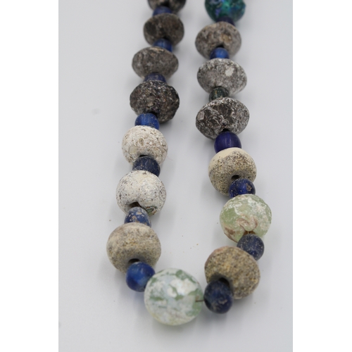 284 - Ancient Roman glass necklace or bead showcasing a captivating patina.

Roughly 35cm long