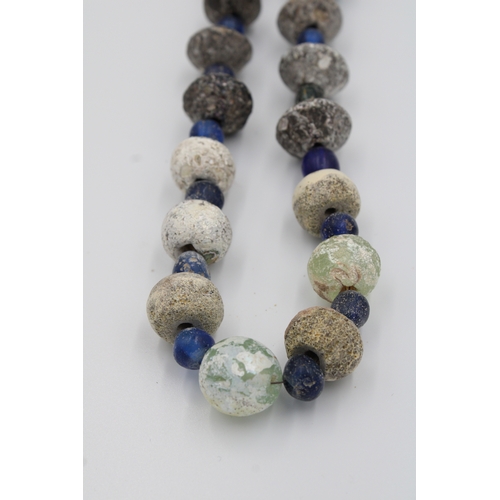 284 - Ancient Roman glass necklace or bead showcasing a captivating patina.

Roughly 35cm long