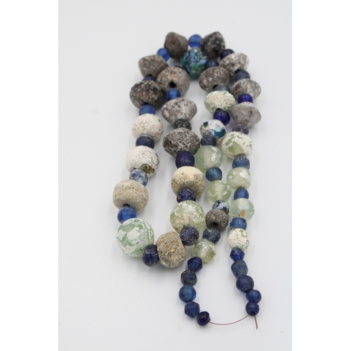 284 - Ancient Roman glass necklace or bead showcasing a captivating patina.

Roughly 35cm long