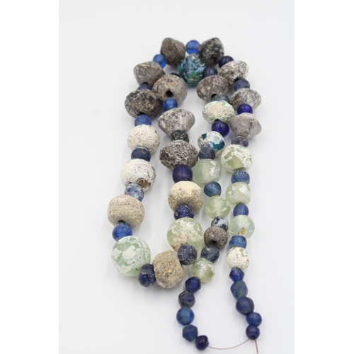 284 - Ancient Roman glass necklace or bead showcasing a captivating patina.

Roughly 35cm long