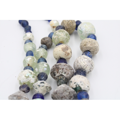 284 - Ancient Roman glass necklace or bead showcasing a captivating patina.

Roughly 35cm long