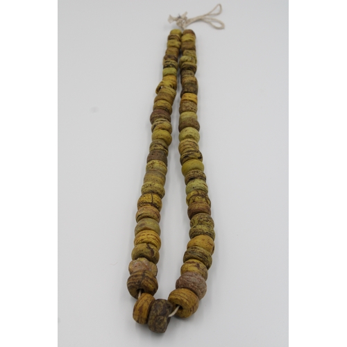 292 - Antique African glass necklace in yellow, approximately 34 cm long.