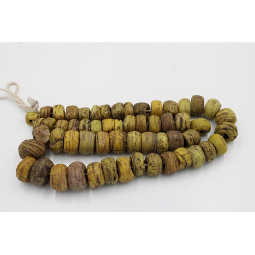 292 - Antique African glass necklace in yellow, approximately 34 cm long.