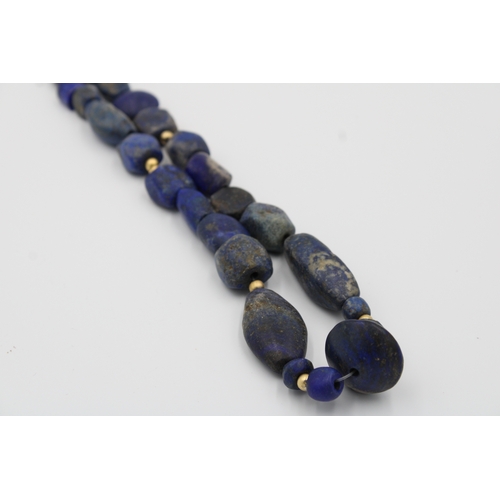 294 - Lapis lazuli necklace, measuring 33 cm in length, adorned with intricate yellow metal beads for adde... 