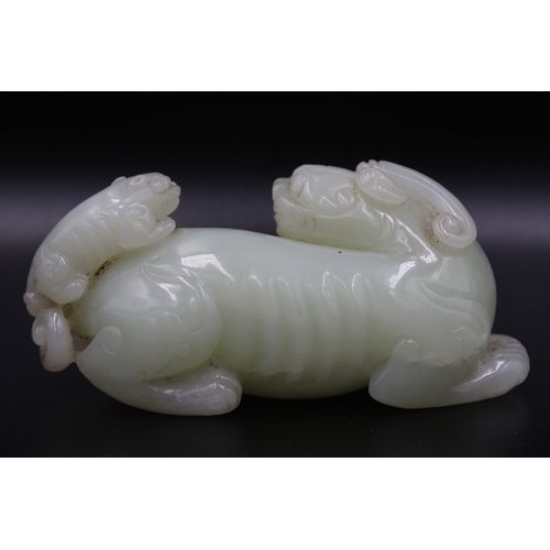 46 - This stunning Chinese jade sculpture portrays a mythical lion with its cub, showcasing intricate det... 