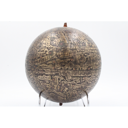 120 - This sizable Islamic brass celestial globe, adorned with intricate copper inlay and meticulously car... 