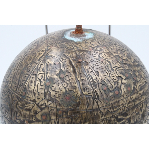 120 - This sizable Islamic brass celestial globe, adorned with intricate copper inlay and meticulously car... 