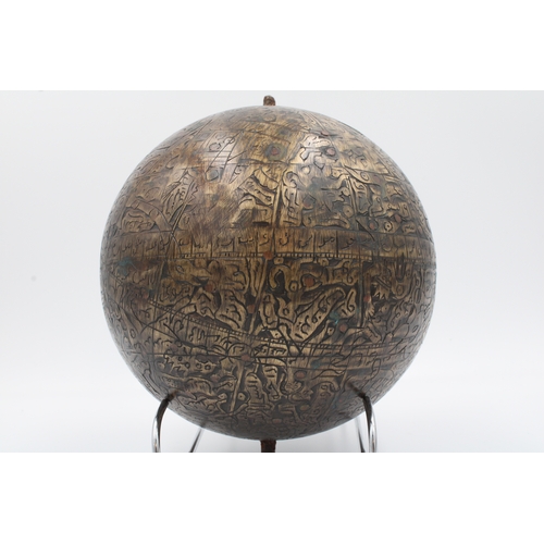 120 - This sizable Islamic brass celestial globe, adorned with intricate copper inlay and meticulously car... 