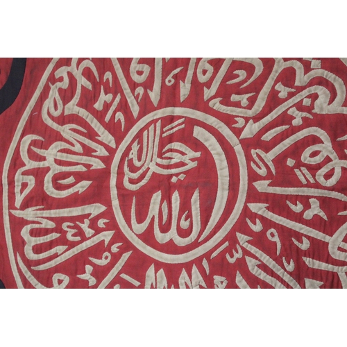 108 - This Ottoman textile features a striking Qur'anic inscription in red, beige, and black hues. In exce... 