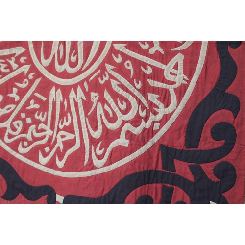 108 - This Ottoman textile features a striking Qur'anic inscription in red, beige, and black hues. In exce... 