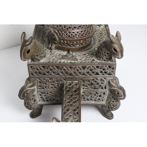 125 - Islamic bronze incense burner adorned with intricate openwork and delicate silver inlaid. This stunn... 