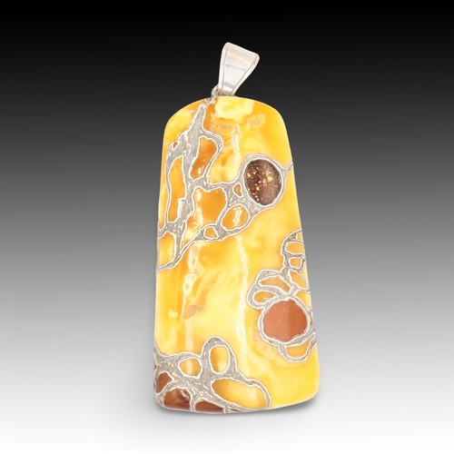 428 - A Butterscotch Amber Pendant with Intricate Silver Inlay

Height: Approximately 12.2 cm
Weight: 96.2... 