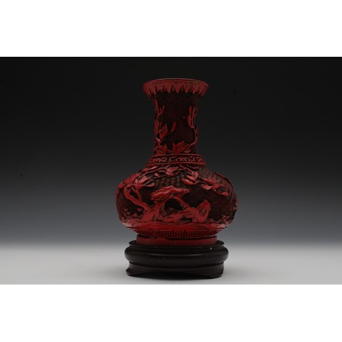 355 - A Chinese Cinnabar Lacquer Vase with a Wooden Base.

H with Stand: Approximately 21cm 
H: Approximat... 