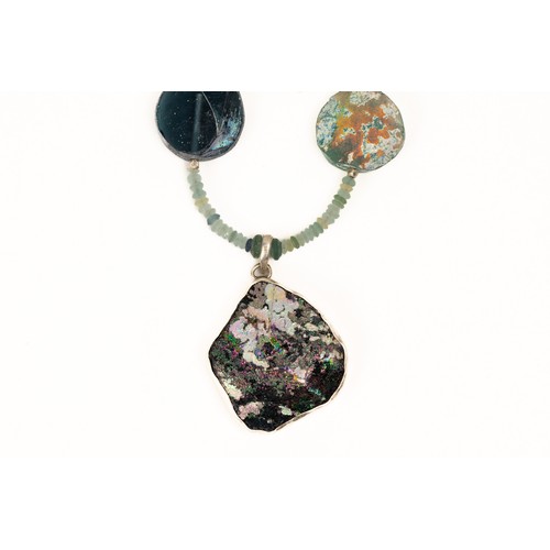 196 - A Roman Glass Bead Necklace with a Circular Silver Pendant with Lovely Patina. 

L: Approximately 59... 