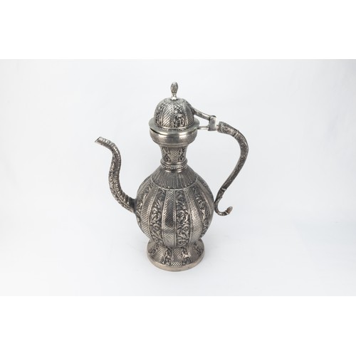 128 - An Indian White Metal Ewer Decorated with Intricate Carvings of Floral Patterns.

H: Approximately