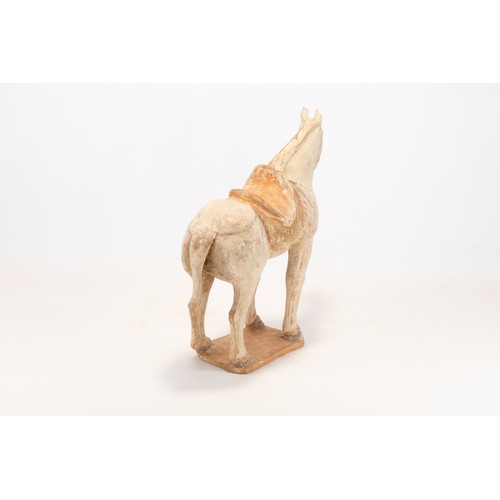 104 - A Chinese Pottery Figure of a Horse with a Saddle from the Tang Dynasty.

H: Approximately 28cm
L: A... 