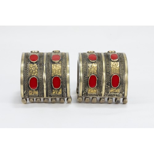 312 - A Pair of Turkmen Yomud Style White Metal Gilded Bangles Decorated with Red Bakelite.

364g