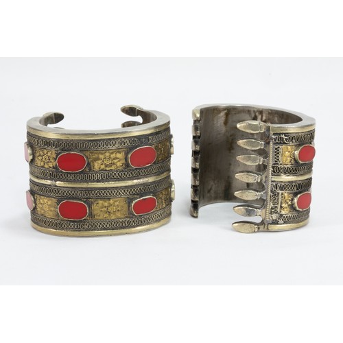 312 - A Pair of Turkmen Yomud Style White Metal Gilded Bangles Decorated with Red Bakelite.

364g