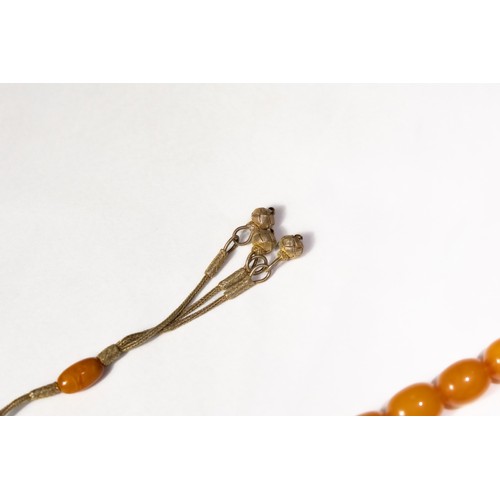 123 - An Islamic Butterscotch Amber Tasbih Prayer Beads with Silver Tassels. 

97g

Half breaded length: A... 