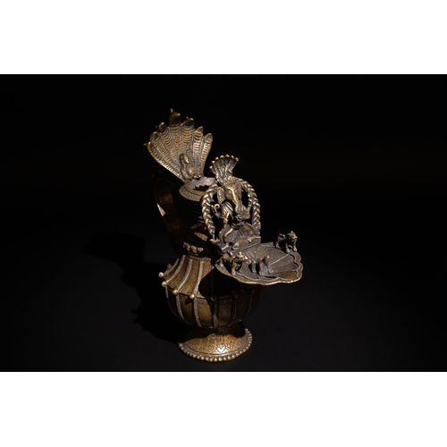 87 - An Indian Bronze Oil Lamp, Decorated with Mythical Beasts on the Bowl & a Man on the Handle.

H: App... 