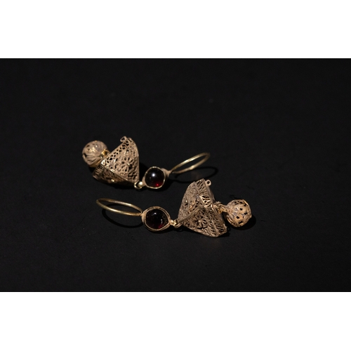 123 - A Pair of Islamic Fatimid Gold Filigree Earrings, 10-12th Century, with Garnet Stones.

8.9g