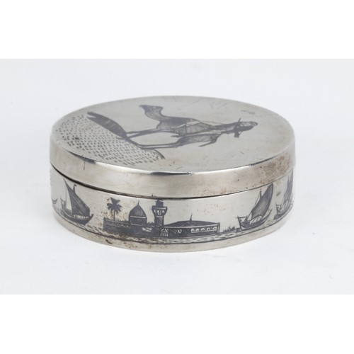 76 - An Islamic Iraqi Niello-Silver Pill Box with Desert and Maritime Motifs.

The lid features an engrav... 