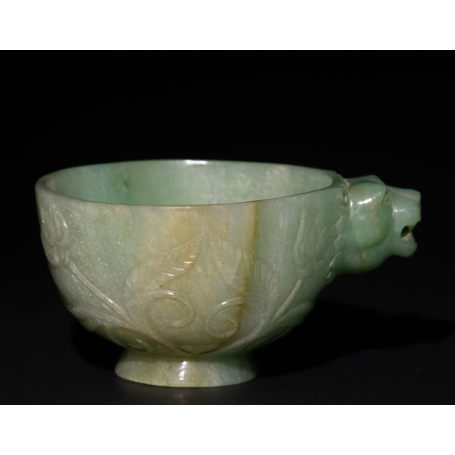 158 - A Mughal-Style Green Jade Bowl with Lion-Head Handle.

The bowl is adorned with floral motifs delica... 