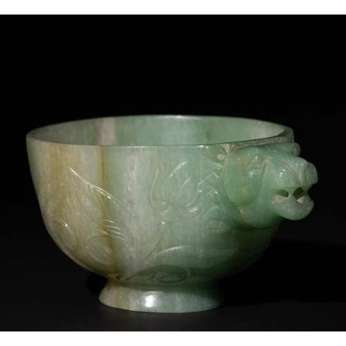 158 - A Mughal-Style Green Jade Bowl with Lion-Head Handle.

The bowl is adorned with floral motifs delica... 